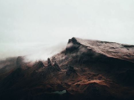 Majestic rocky mountain shrouded in mist, capturing the mysterious atmosphere of rugged terrain.