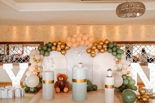 Stylish birthday decor featuring balloons and teddy bear in an elegant indoor setting.