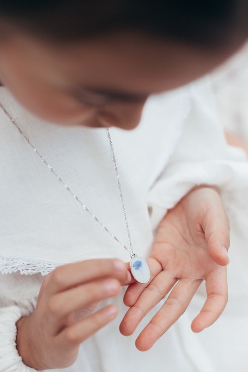 Free Close-up of a child admiring a pendant necklace, symbolizing innocence and curiosity. Stock Photo