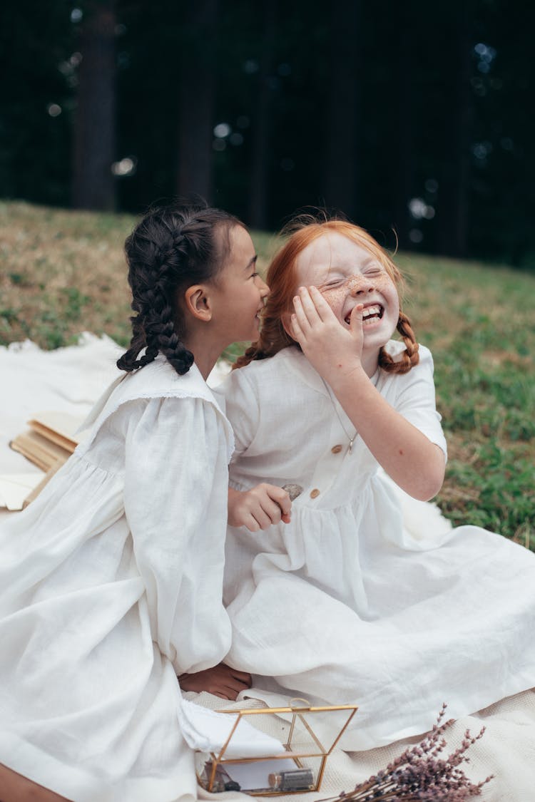 Kids Sitting On A Picnic Blanket Laughing