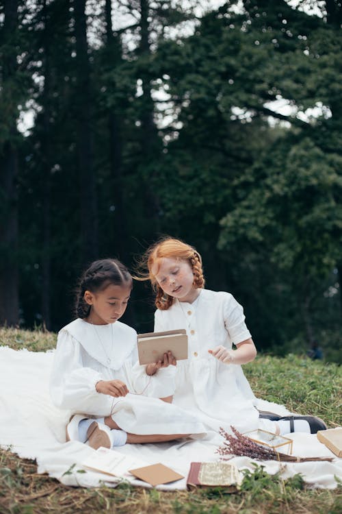 Girls in White Dresses Sitting on Picnic