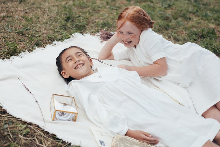 Two Girls In White Dresses On Blanket