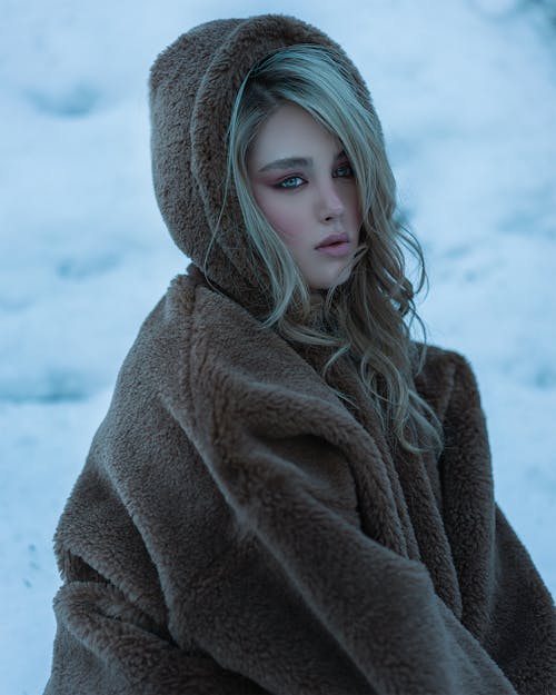 A Woman in Brown Fleece Jacket on a Snow Covered Ground