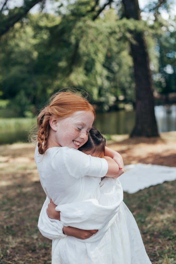 Two Girls Hugging In Park