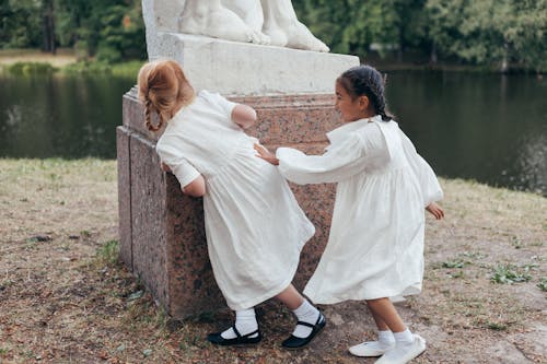 Free Girls in White Dresses Playing in Park Stock Photo