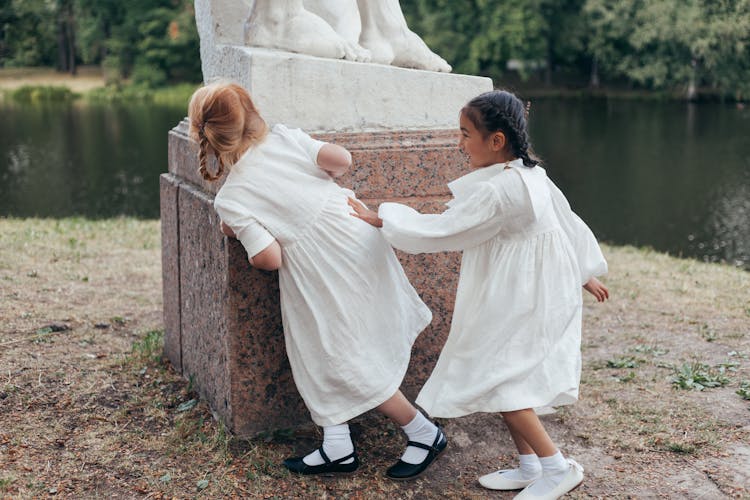 Girls In White Dresses Playing In Park