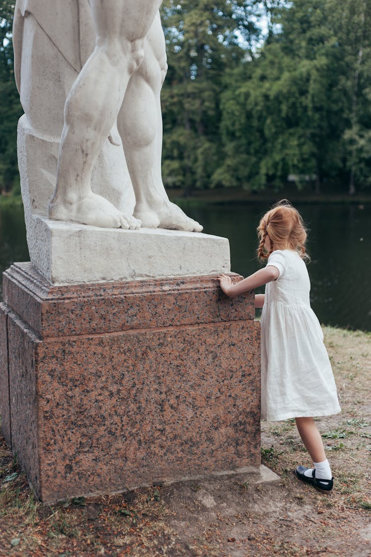 Girl Playing In Park Near Statue