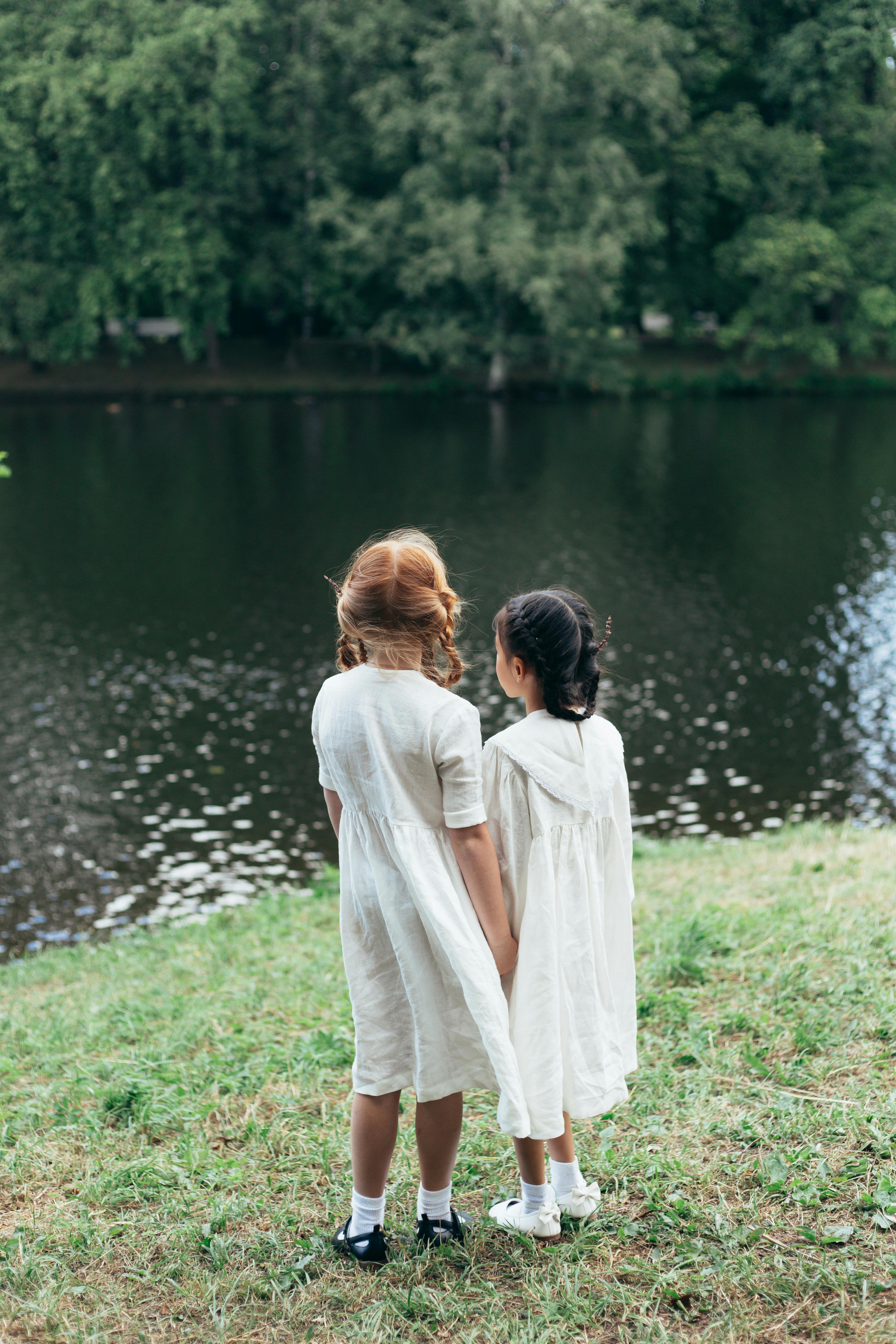 girls in white dresses holding hands