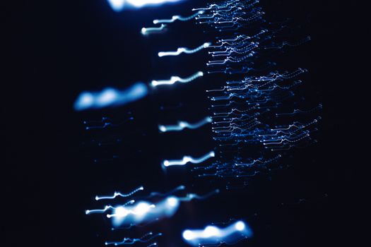 Dynamic abstract photograph of blue light patterns with a dark backdrop, creating a sense of motion and mystery.