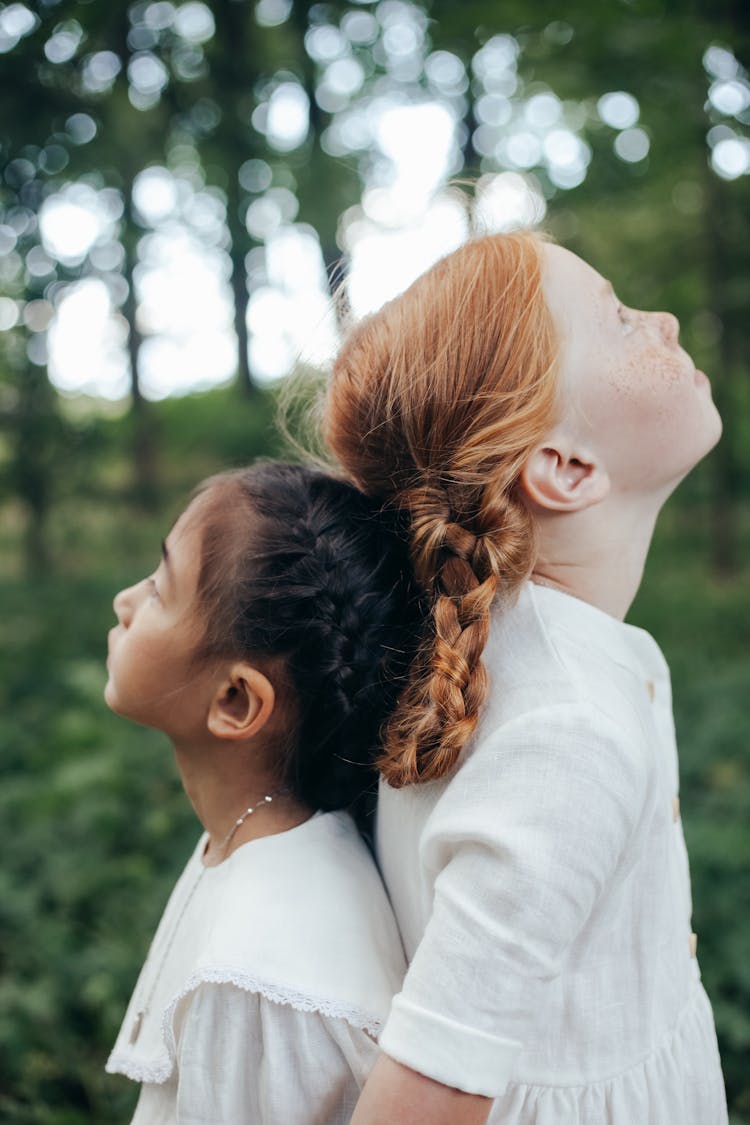 Two Girls Standing Back To Back