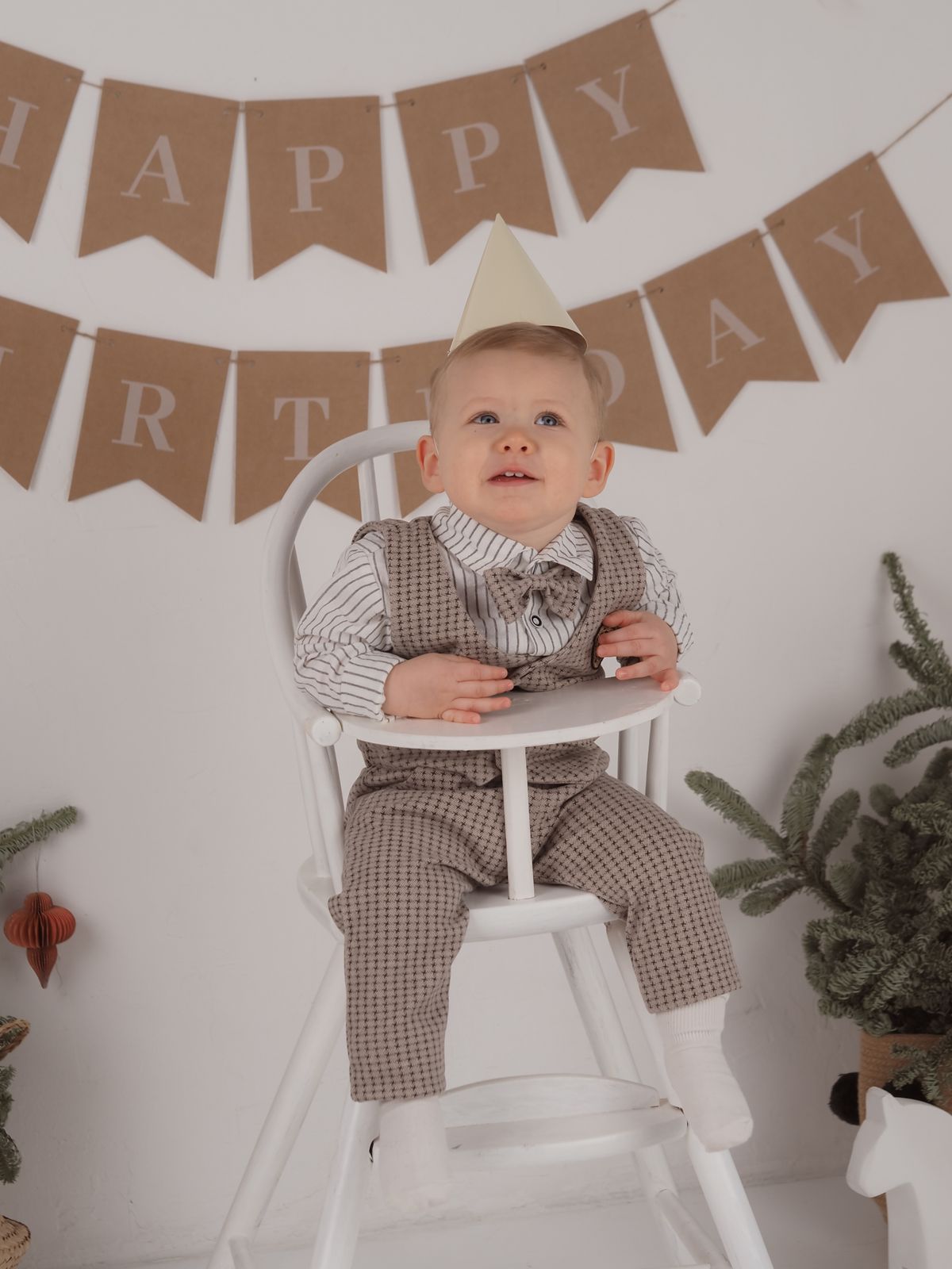 Toddler in a high chair with a party hat