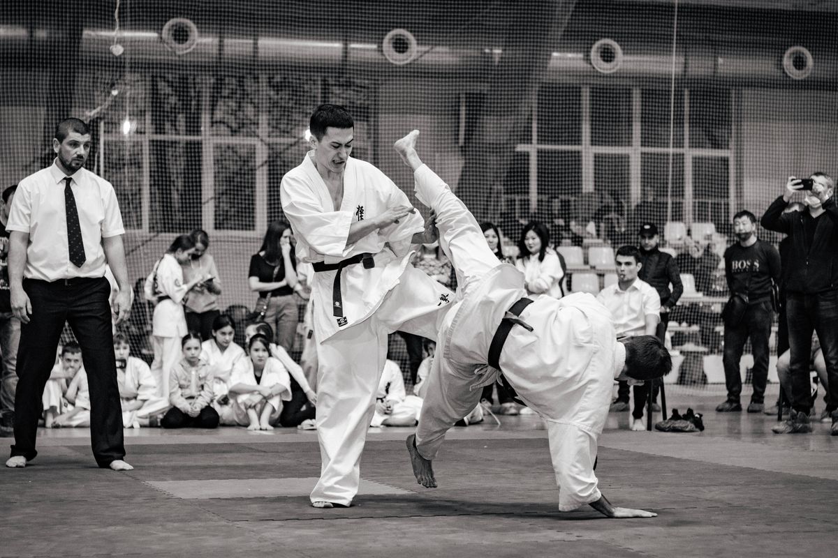 Two karate athletes in close exchange during a bout