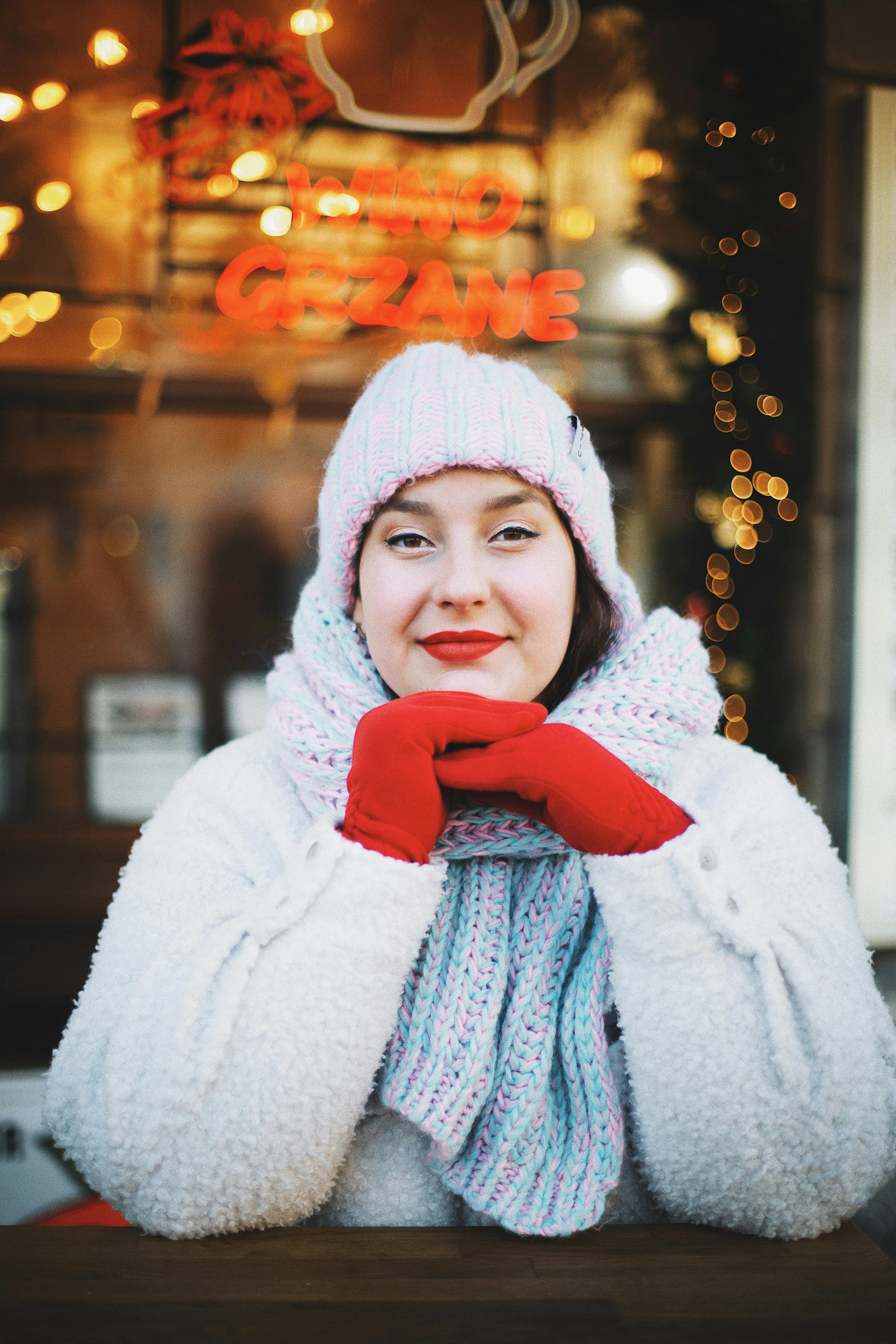 Cheerful woman in winter clothing smiling outside a cafe in Warsaw.