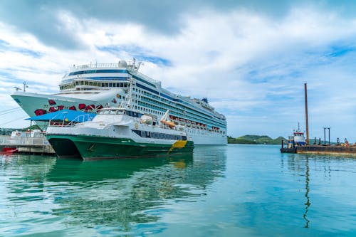 White Cruise Ship on Sea Under White Clouds and Blue Sky