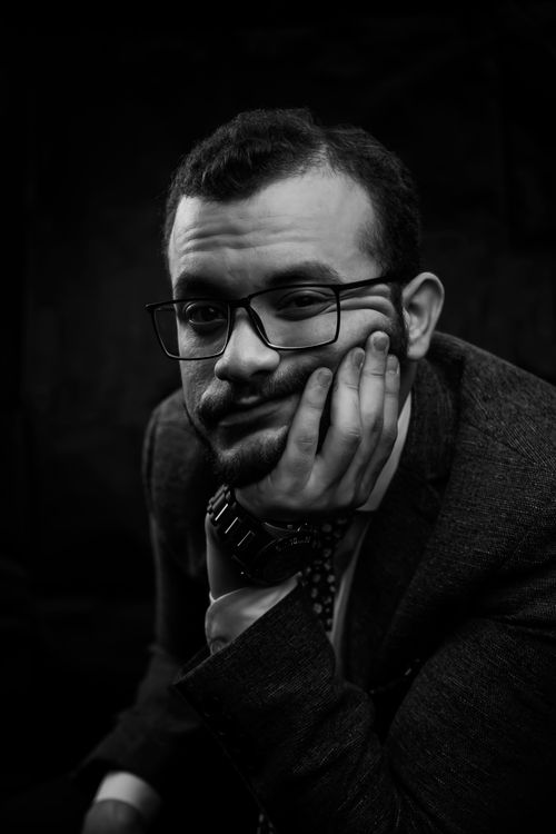 Free Black and white portrait of a pensive man with eyeglasses and hand on face. Stock Photo