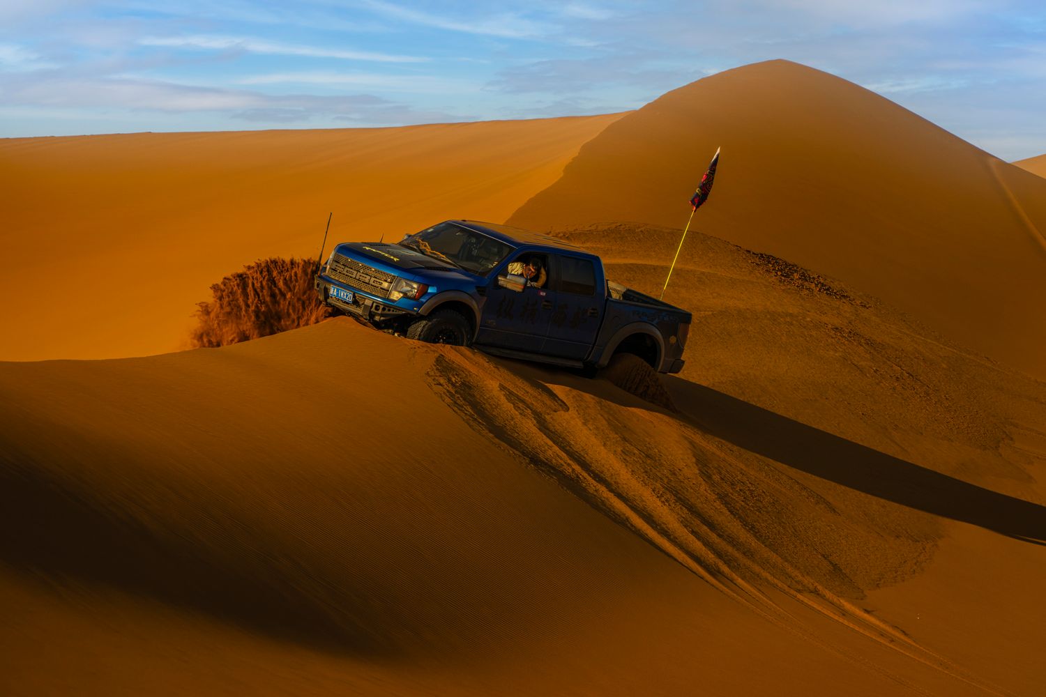 Pickup truck on desert sand dunes where traction boards excel for self-recovery from soft sand