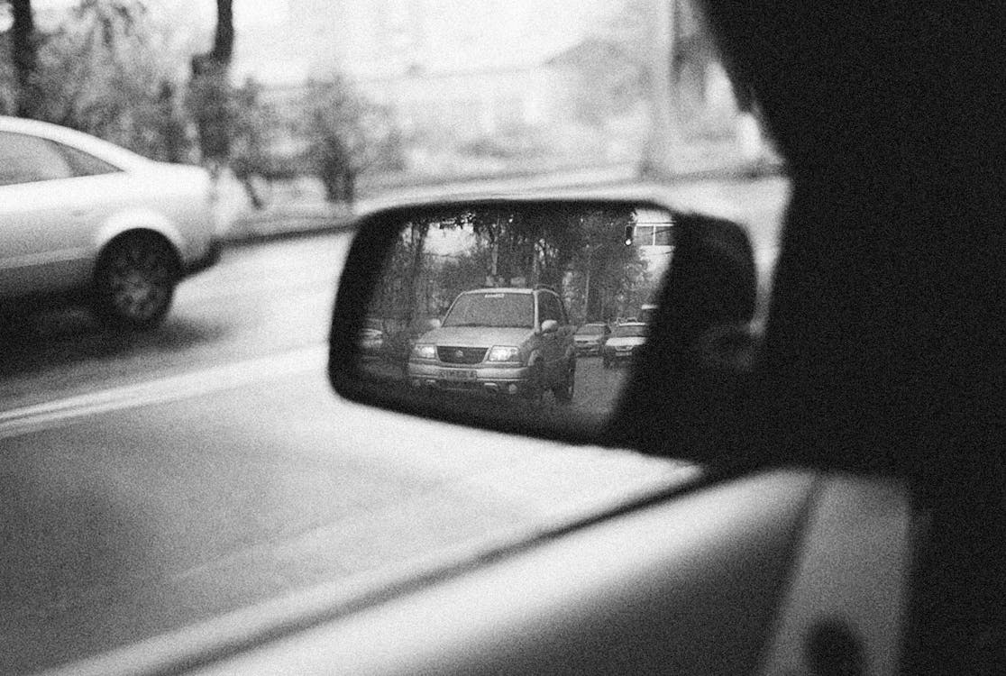 A Grayscale of a Side Mirror of a View of the Road with Cars