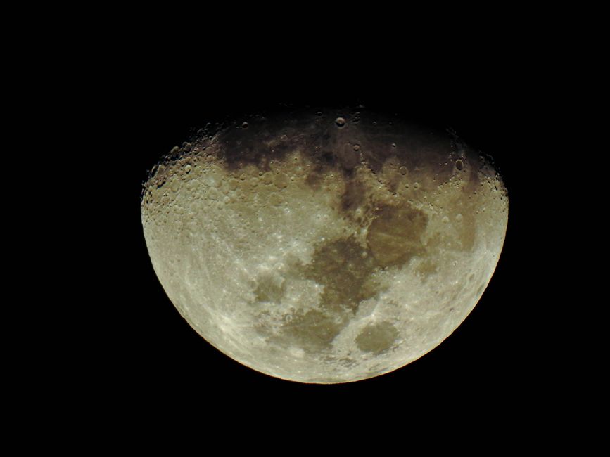 Detailed close-up of the waxing gibbous moon's surface with craters and shadows.