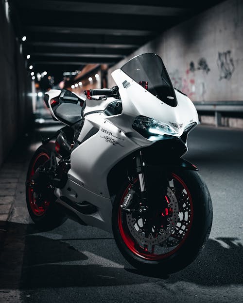 White and Black Sports Bike Parked on Gray Concrete Road