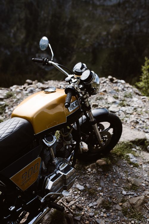 Free A classic Ducati motorcycle parked on rocky ground under natural light. Stock Photo