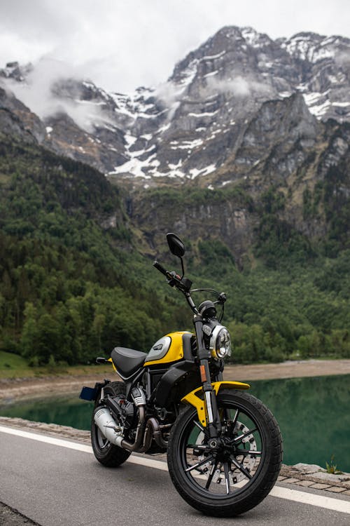 Free Yellow and Black Motorbike Parked Near the Lake  Stock Photo