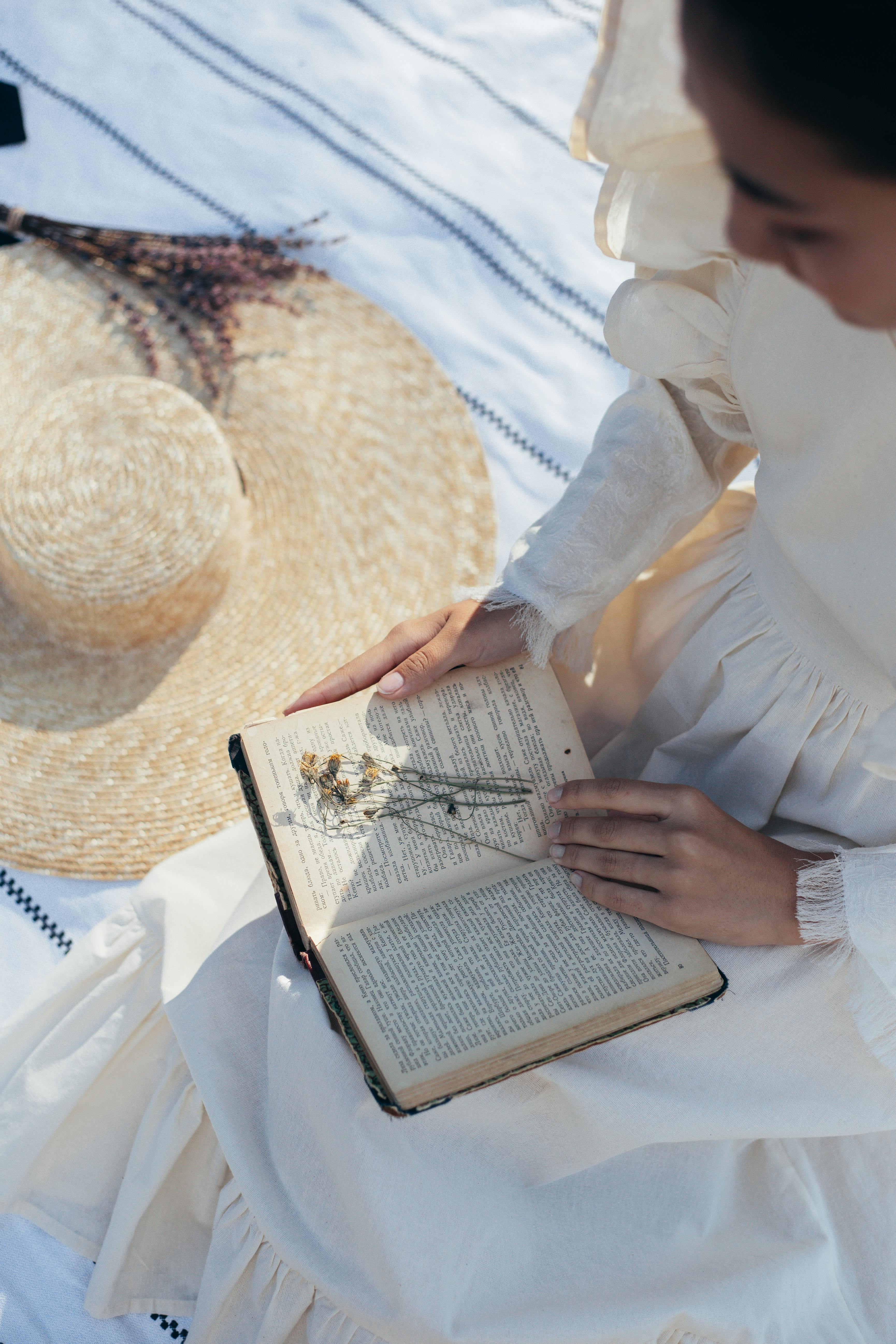 high angle view of woman in white dress reading book