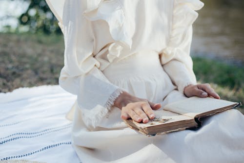 Mid Section of Woman in White Dress Reading Book