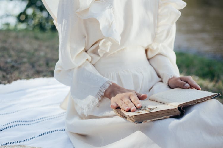 Mid Section Of Woman In White Dress Reading Book