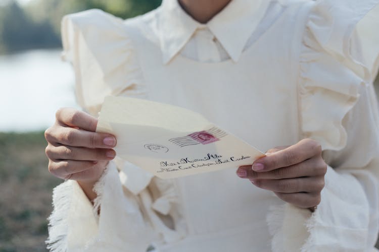 Mid Section Of Woman In White Dress Holding Letter