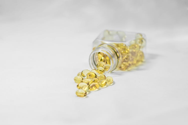 Yellow Softgel Capsules On White Surface 