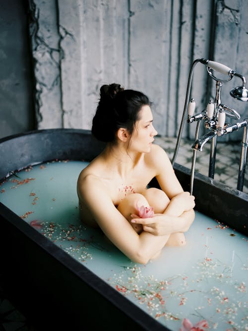 Free Naked Woman Sitting in Water in Bathtub Stock Photo