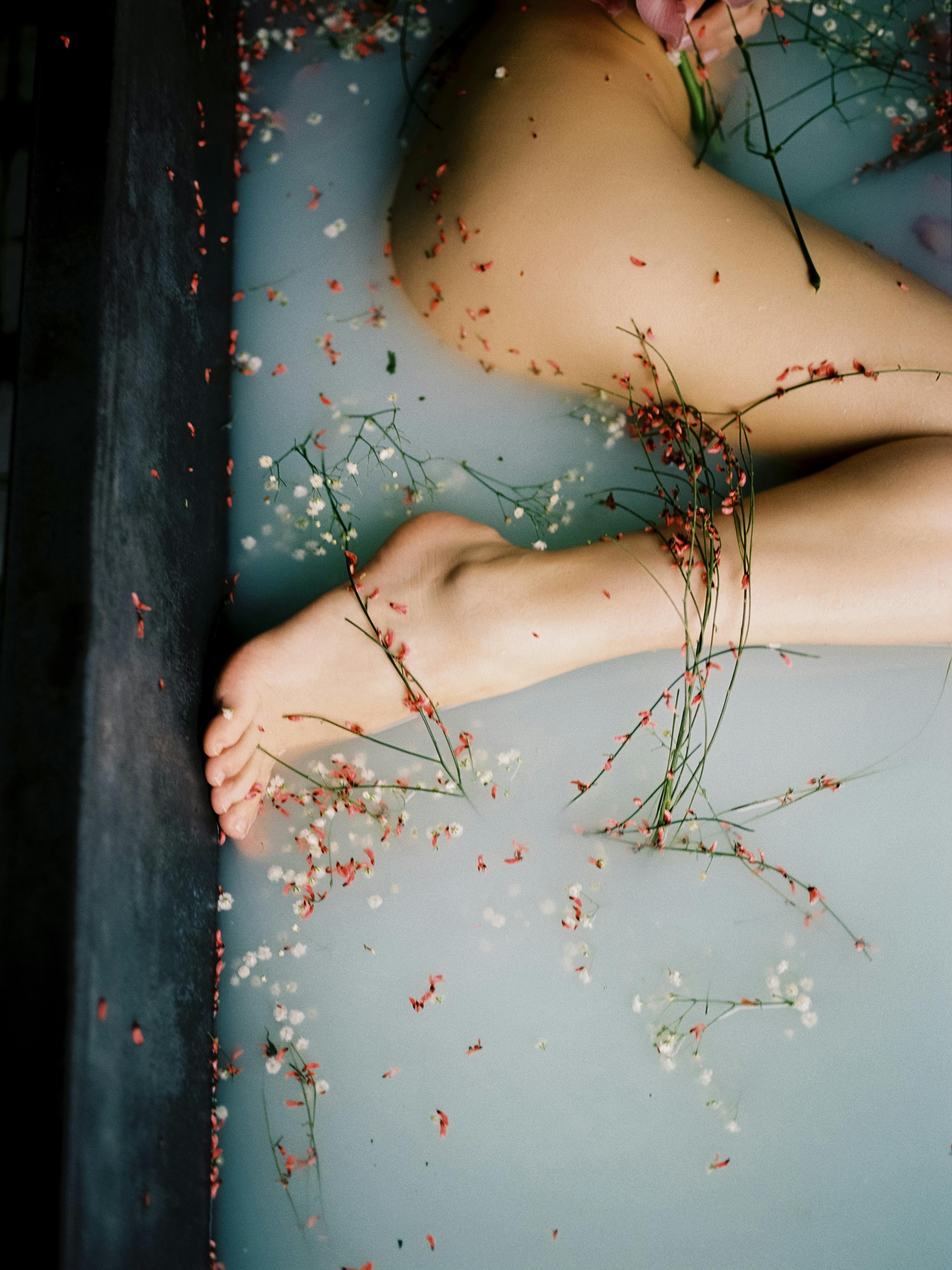 naked woman taking bath in milk and flowers