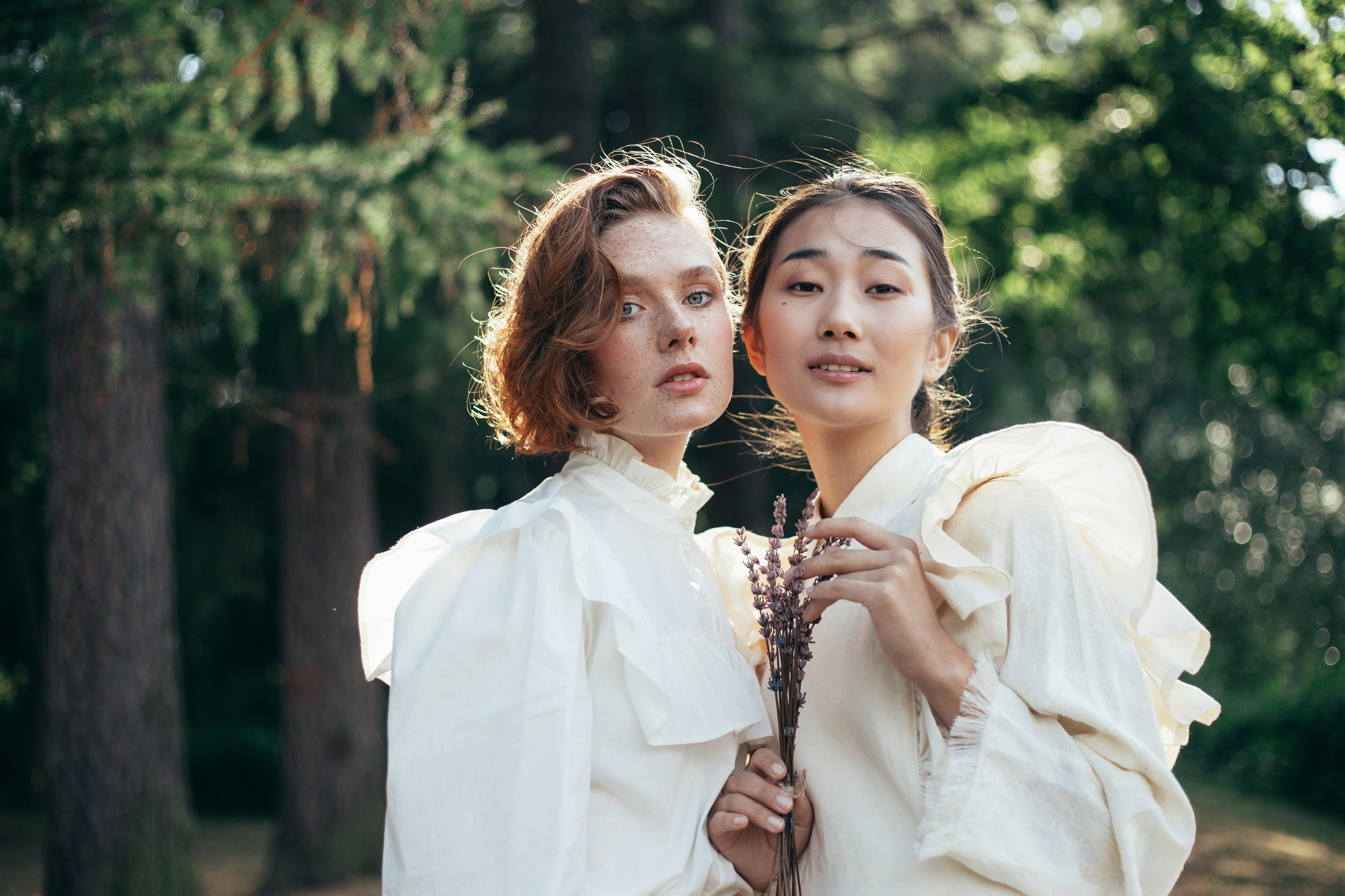 portrait of two women in old fashioned clothing standing in park