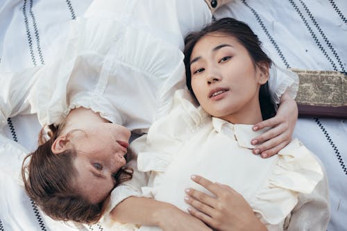 Free Women in Old-Fashioned Clothing Lying on Picnic Blanket Stock Photo