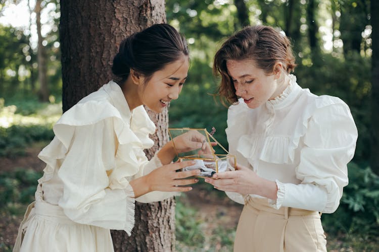 Women Opening A Clear Glass Box 