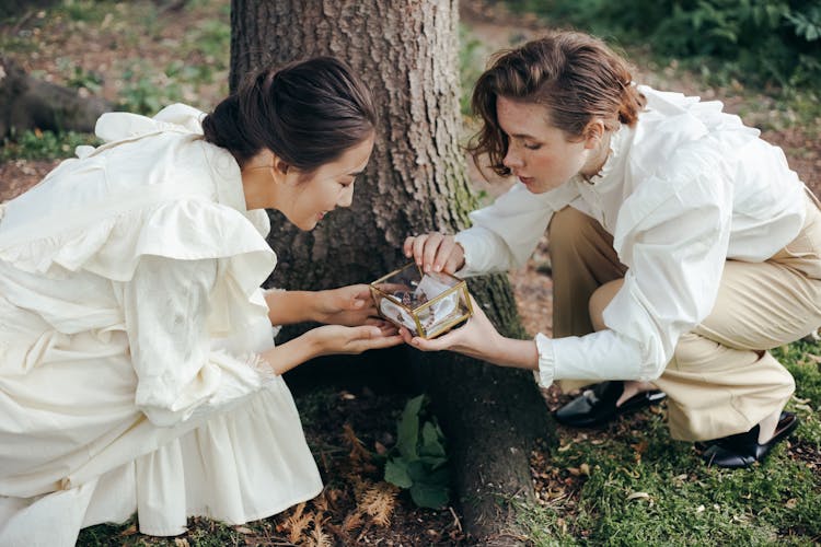 Women Looking At An Acrylic Box