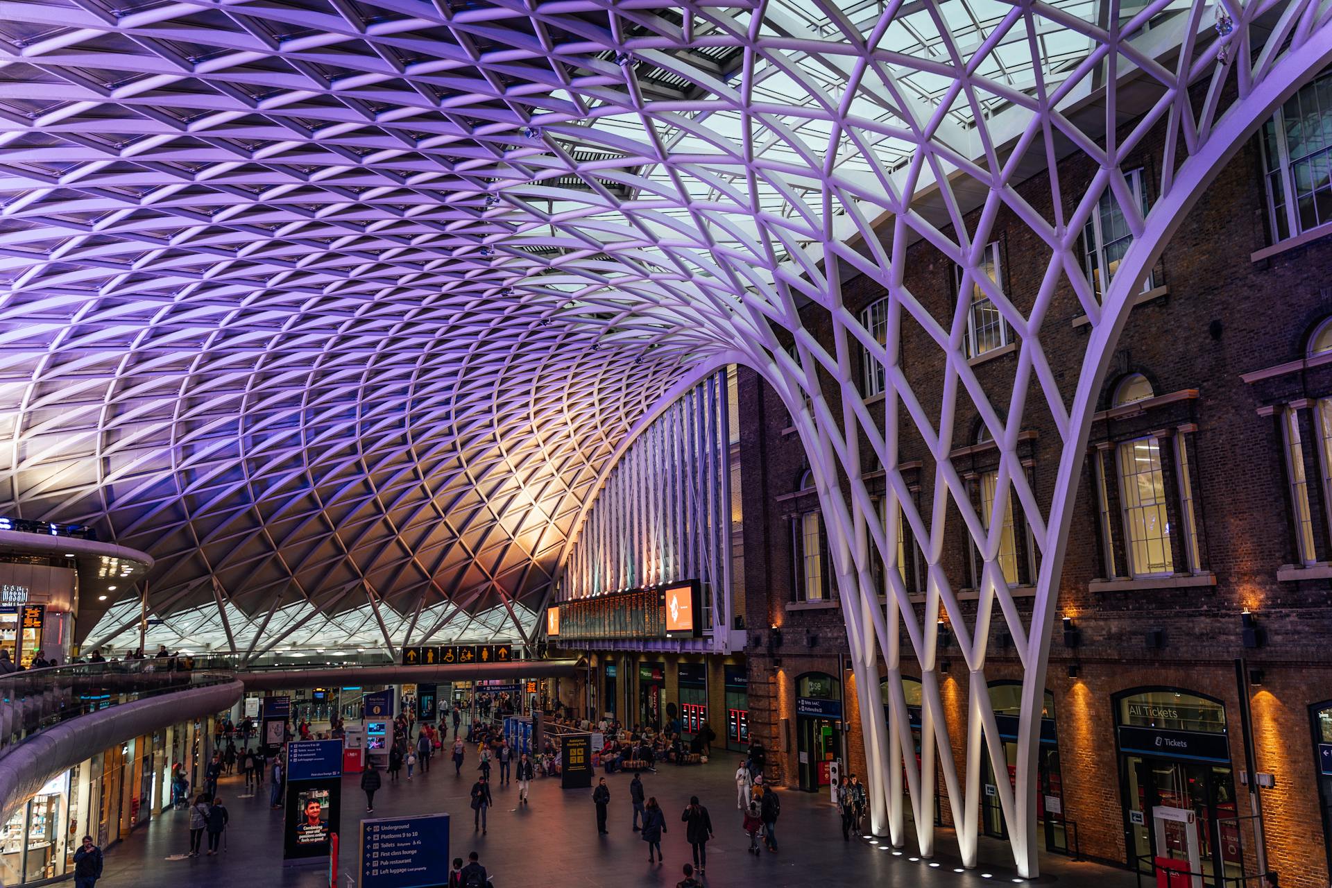 Explore the stunning architectural design of King's Cross Station in London with its intricate lattice roof structure.