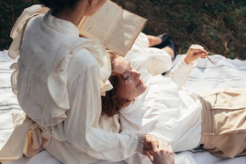 Free Women in Old-Fashioned Clothing on Picnic Blanket in Park Stock Photo