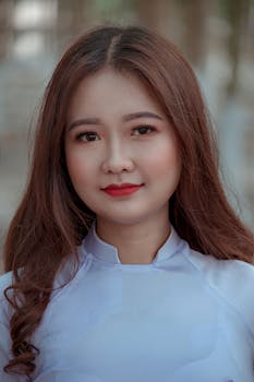 一位妆容微妙的棕色长发女性特写肖像，突显了她的自然美