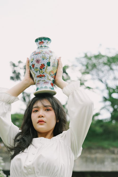 Woman Holding Painted Vase on Her Head