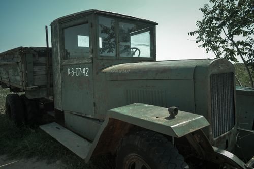 Free An old, rusted military truck parked in a field, showing signs of decay. Stock Photo