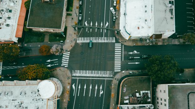 Drone shot of city intersection showcasing road markings and vehicles.