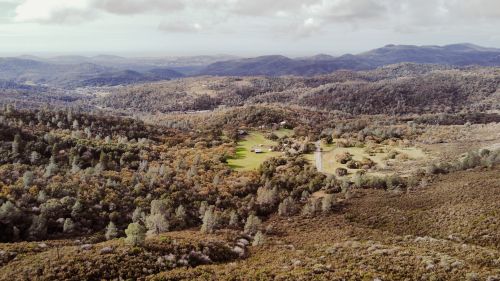 Free Breathtaking aerial view of lush countryside with rolling hills and dense forests. Stock Photo