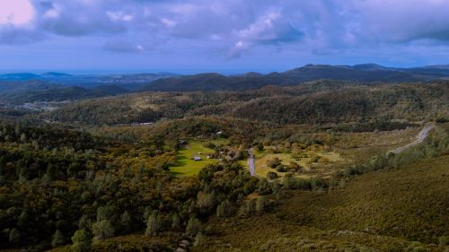 Free Stunning aerial shot of lush countryside with green hills and blue sky. Stock Photo