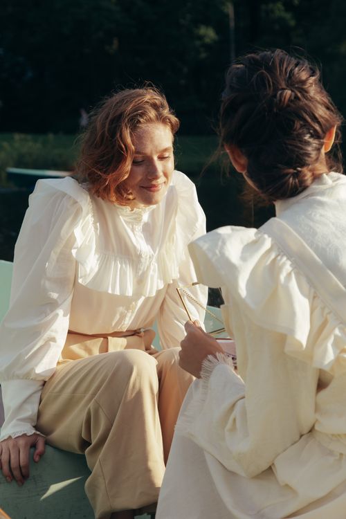 Free Two women enjoy a serene moment in the sunlight on a boat, capturing summer's tranquility and friendship. Stock Photo