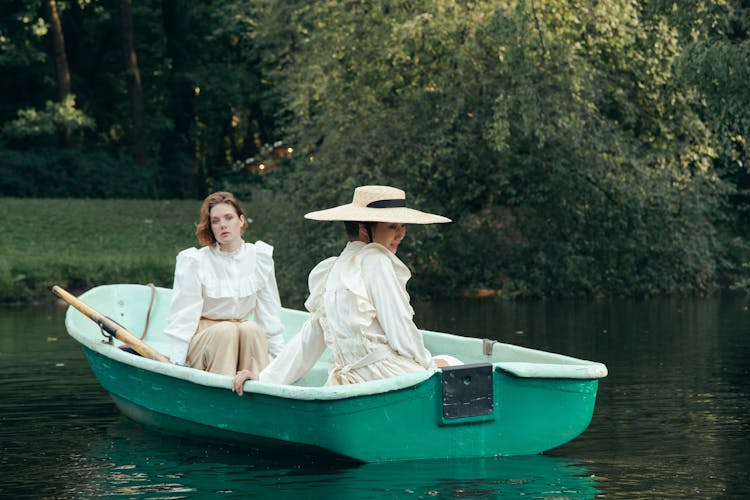 Two Women In 19th Century Outfits On Boat Ride