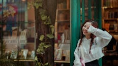 书店外，一位扎着辫子的年轻女子微笑着，洋溢着幸福