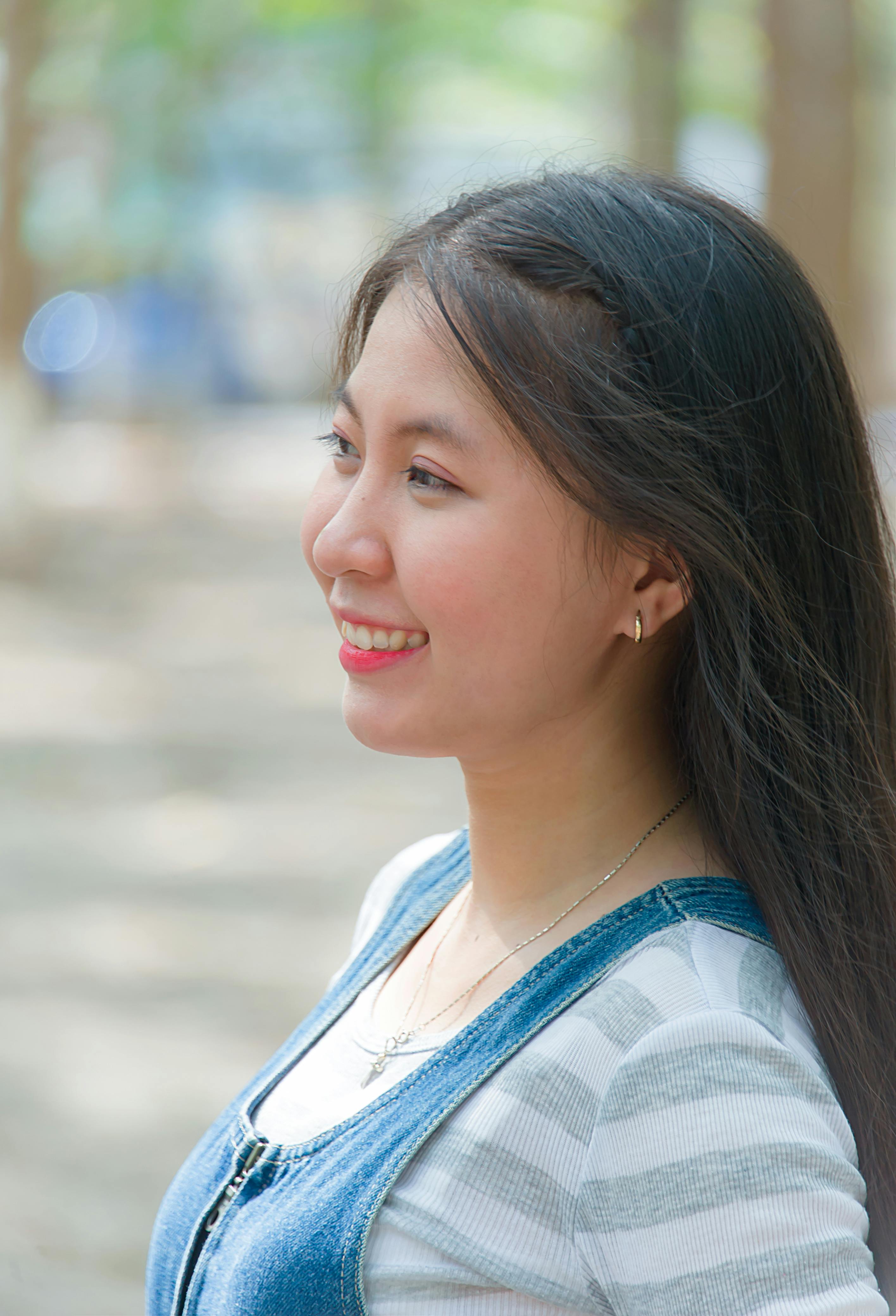 一位在户外阳光下微笑的女人的个人肖像，捕捉到了欢乐与放松