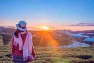 一名女子凝视着广阔田野上充满活力的日出，捕捉到了宁静之美