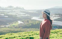 妇女可以欣赏到郁郁葱葱的农田和远处小山的宁静景色